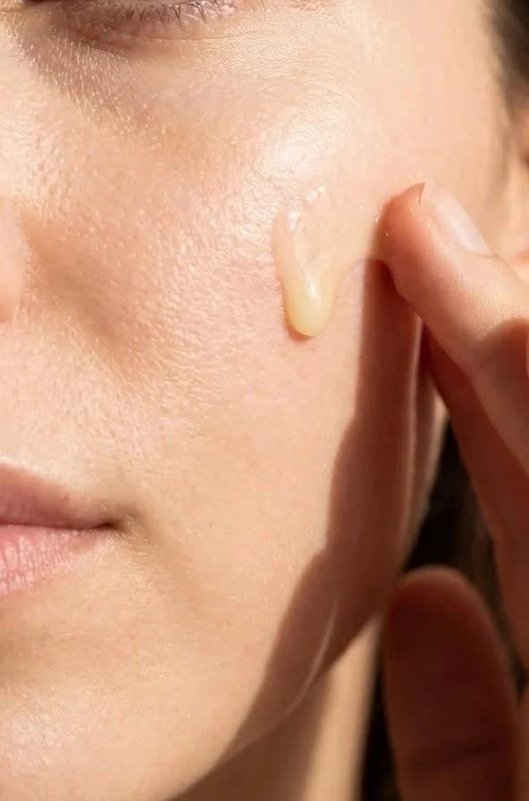 Textura de sérum aplicada sobre la mejilla con la yema del dedo