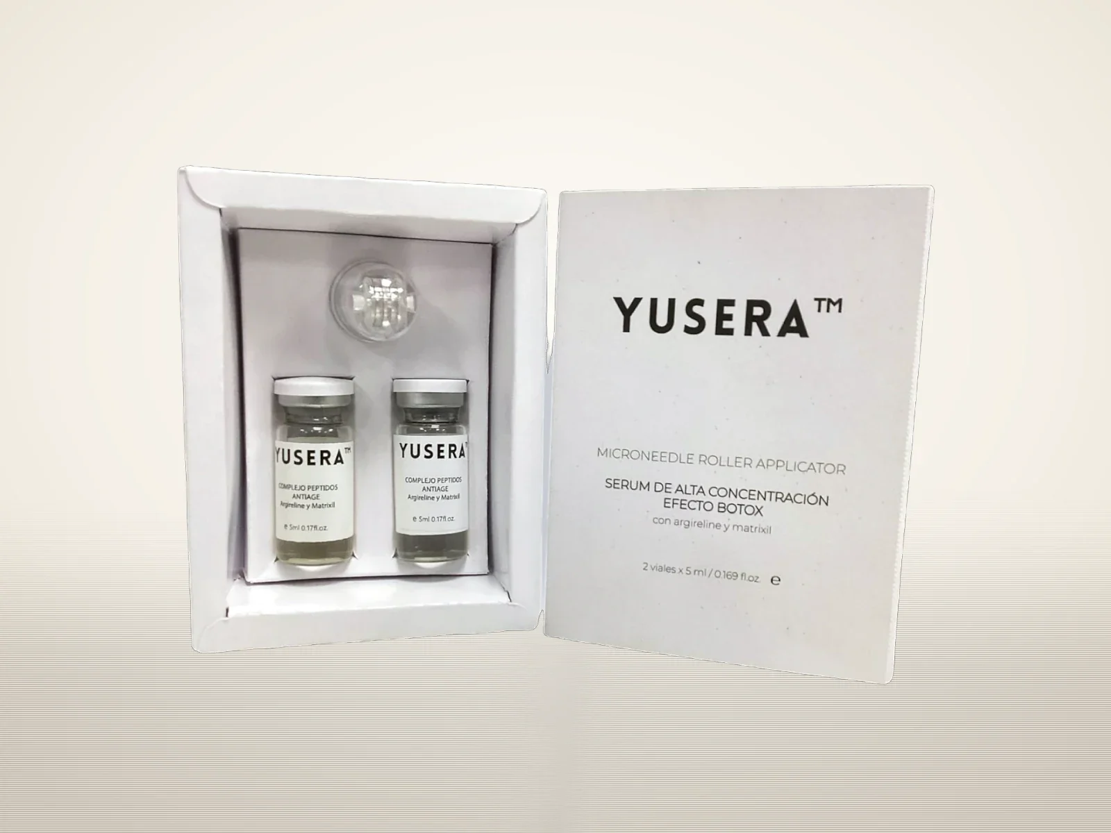 Kit de microneedling de Yusera abierto, con 2 viales de sérum de 5 ml y aplicador roller de microagujas, sobre fondo claro